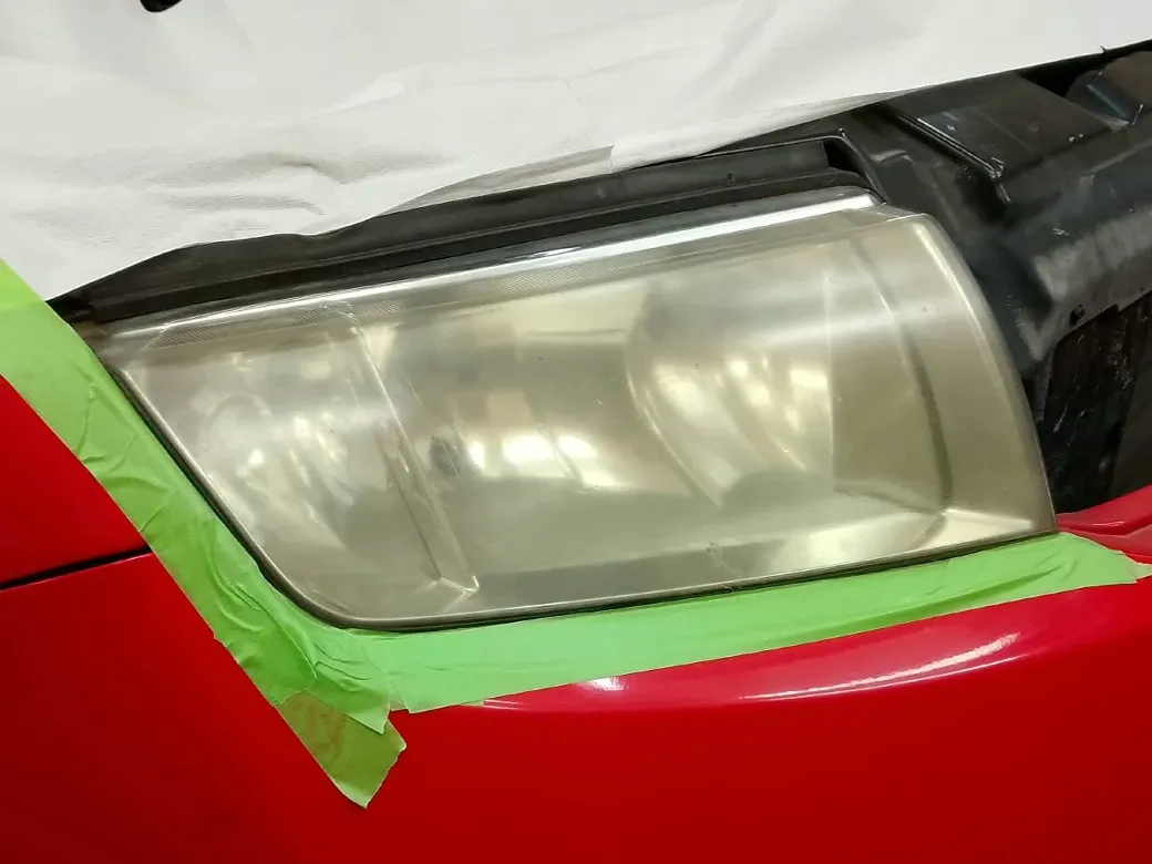 Světlomet červeného automobilu před renovací.
